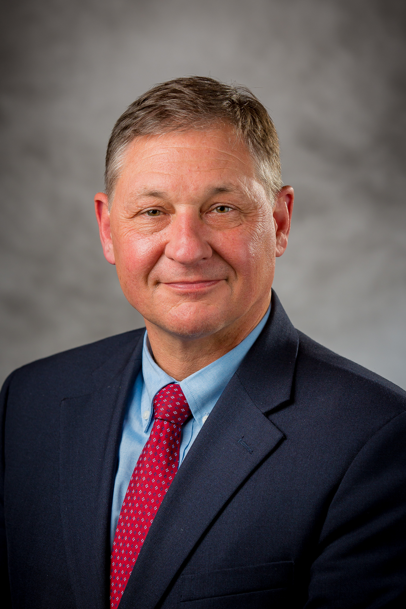 a man wearing a navy blue suit and a red tie