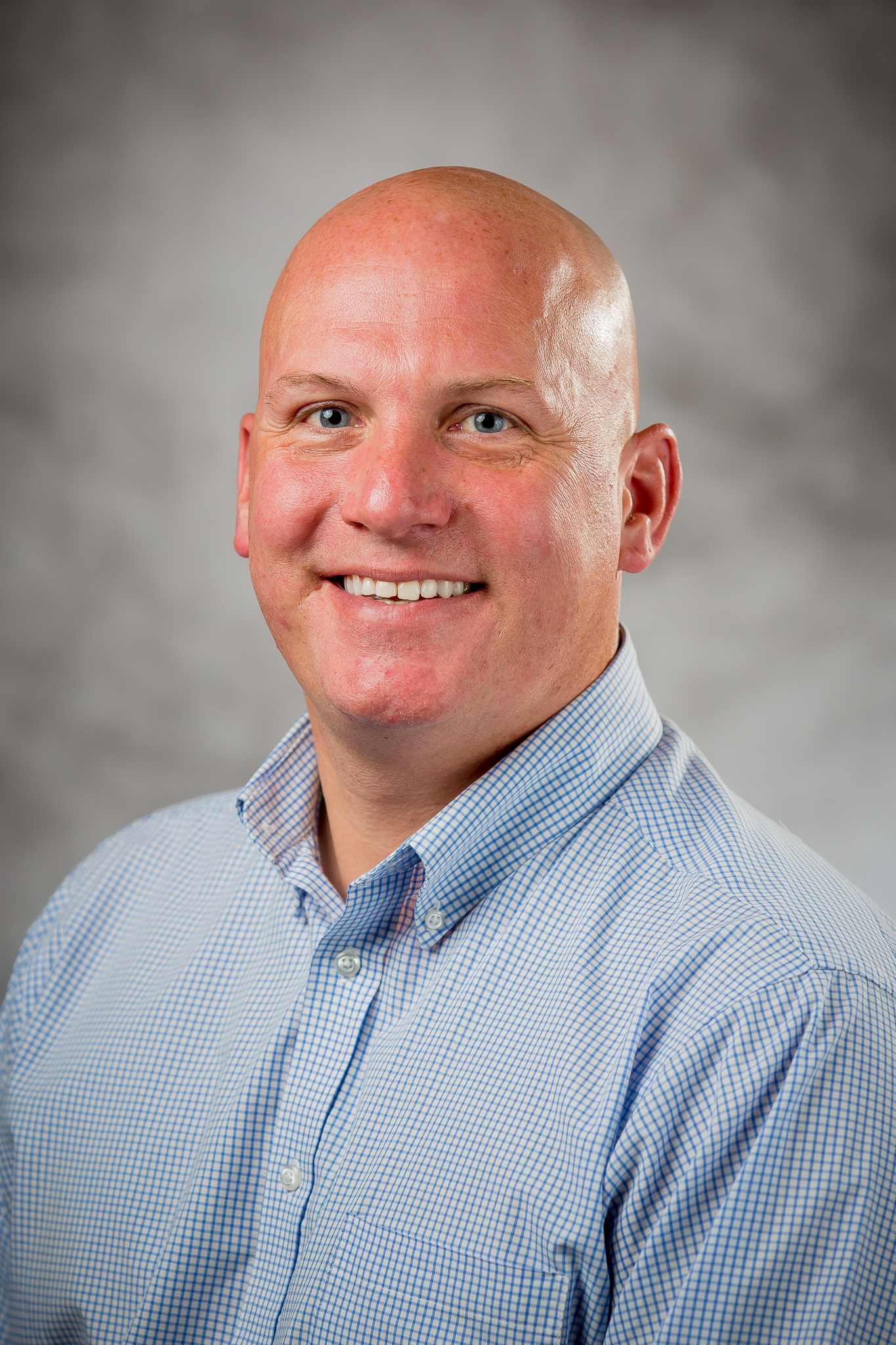 picture of a bald man wearing a blue button up shirt