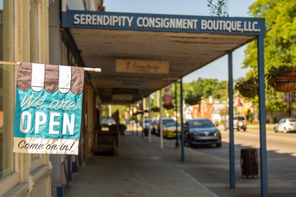 downtown businesses with a flag that says "we are open come on in!"