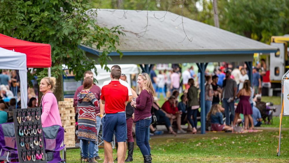 people outside talking, playing game and drinking wine at wine fest