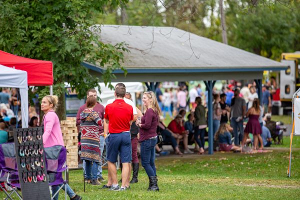 people outside talking, playing game and drinking wine at wine fest